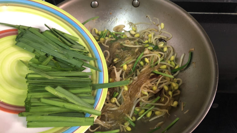 豆芽炒粉条,加入韭菜叶,翻炒均匀