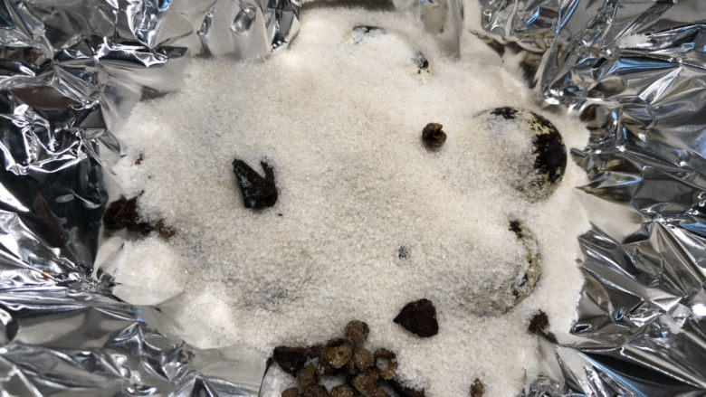 盐焗鹌鹑蛋,再把剩余的盐盖在鹌鹑蛋上,基本上把鹌鹑蛋都覆盖上就可以了