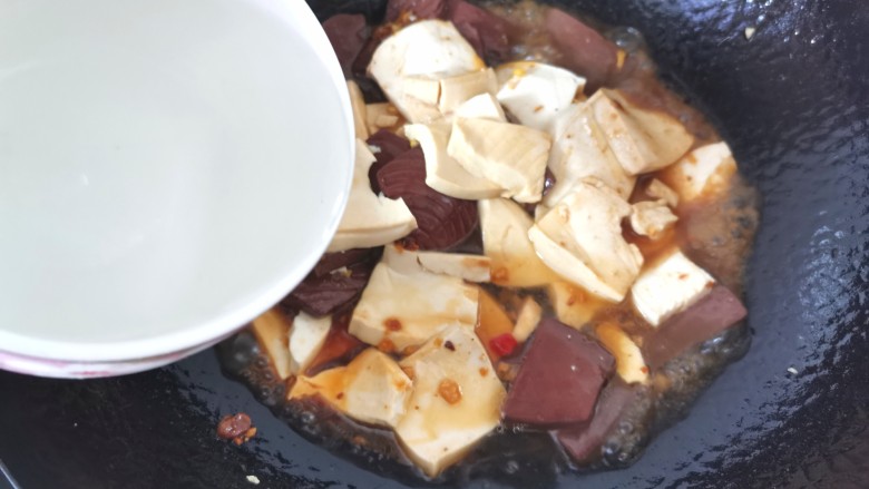 猪血炖豆腐,倒入适量清水,水开烧2分钟