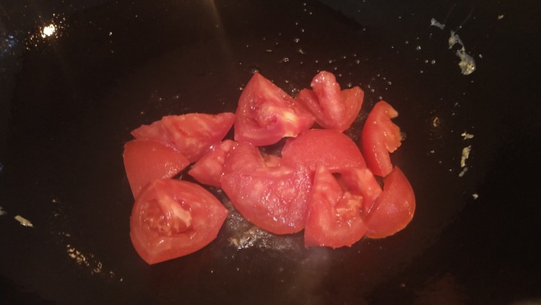 番茄鸡蛋金针菇汤,锅内加油放入番茄炒出汤汁