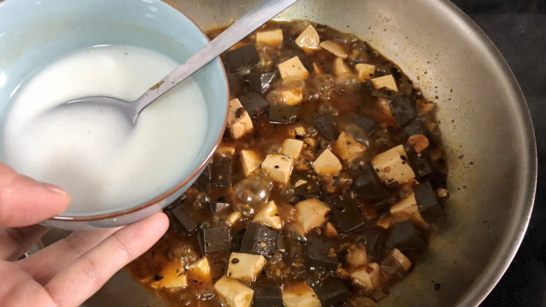 猪血炖豆腐➕红白花开山雨中,加入两汤匙水淀粉,二次勾芡收汁,收汁时不时用铲子推动食材,以免粘锅