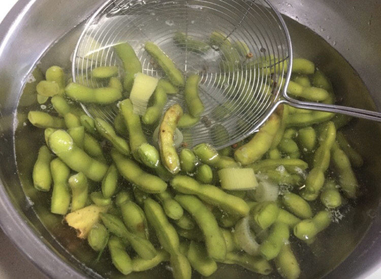 香辣毛豆,煮熟的毛豆捞出,放在冷开水浸泡至冷却。