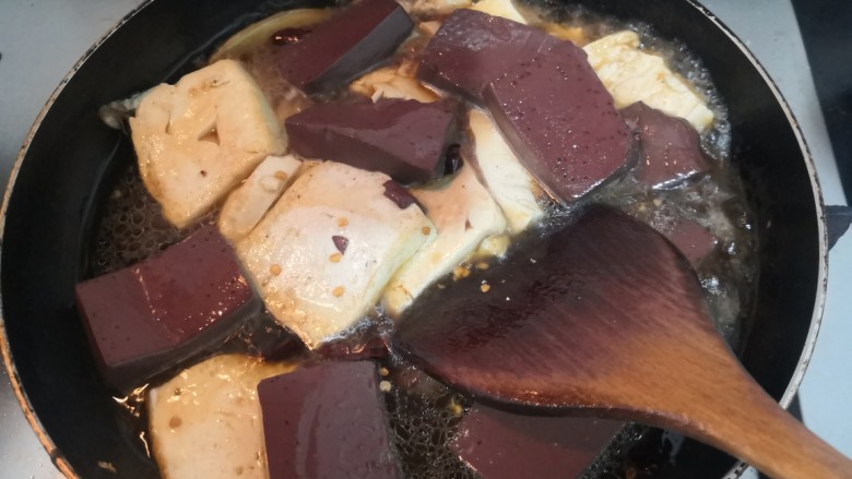 猪血炖豆腐,小心的推拌菜,让其混合均匀后,大火烧煮