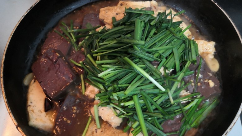 猪血炖豆腐,煮至汤汁浓稠,加入韭菜段