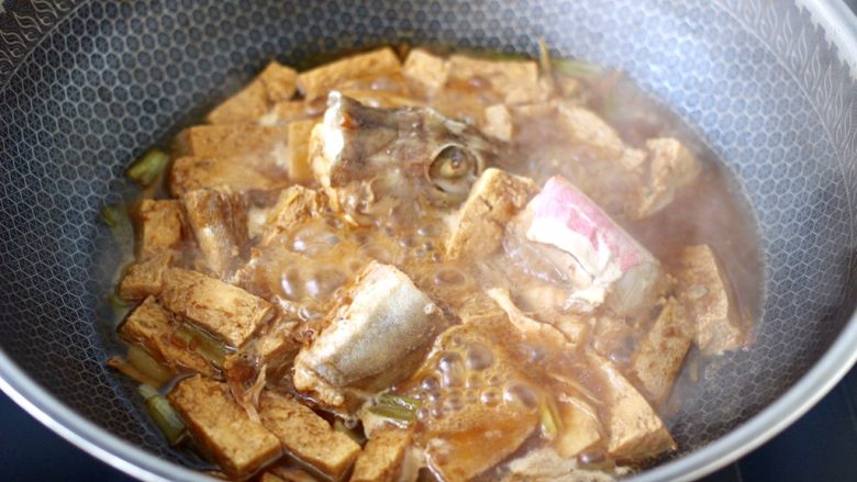 红蟹鱼酱焖冻豆腐,盖上锅盖大火烧开,继续焖煮至锅中汤汁浓稠时。