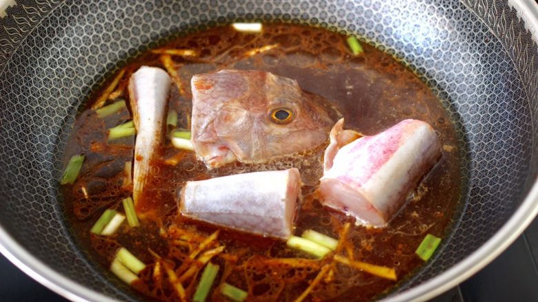 红蟹鱼酱焖冻豆腐,锅中倒入适量的清水,把切段的红蟹鱼放入。