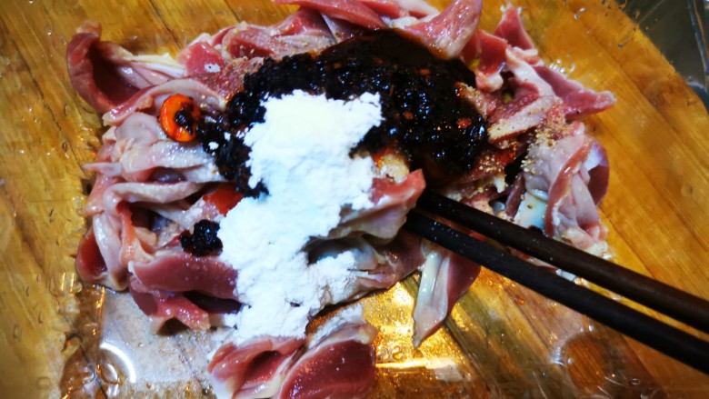 酸豆角辣炒鸡胗,鸡胗片里加入适量盐、胡椒粉、花椒粉、淀粉以及老干妈、耗油,腌制备用