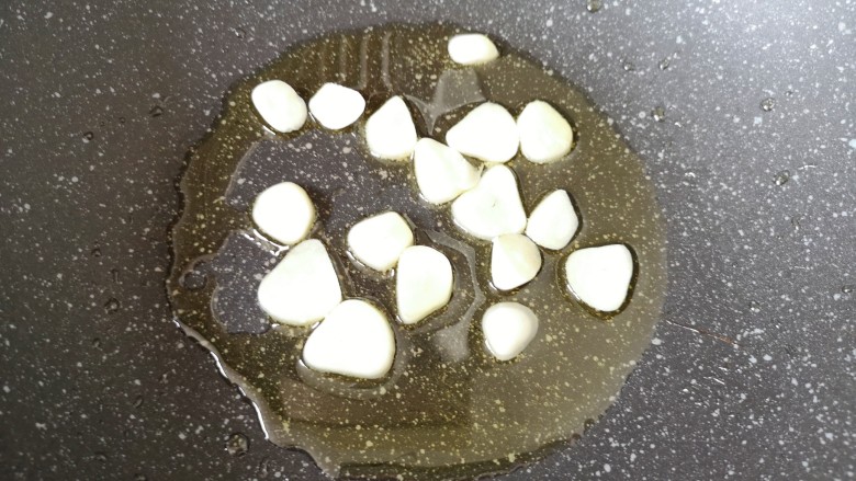 辣炒鸡胗,炒锅内倒适量的食用油烧热,下入蒜片炒香。