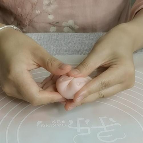 三生三世十里桃花酥,颜值与美味并存,美到醉~~,将第二次卷好的剂子收口朝上,左右两侧往中间按压,然后擀成圆形状