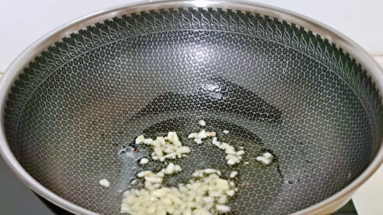 青椒炒腐竹,起油锅,加入切碎的蒜炒出香味。