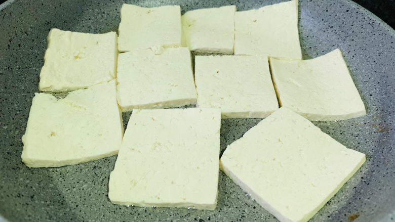 豆腐炒鸡蛋,锅里再加1勺油,热锅,转中火,把豆腐一片片放入煎;