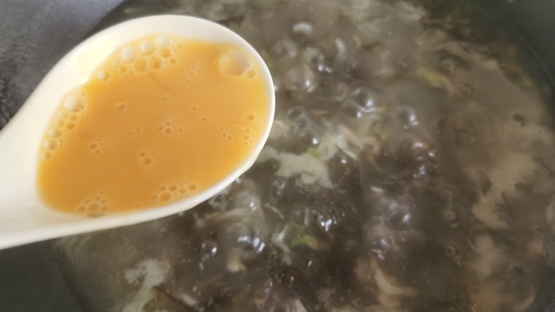 紫菜虾皮汤,一边搅动锅里的汤汁,一边将蛋液徐徐倒入,形成蛋花。