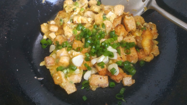 豆腐炒鸡蛋,然后炒散,放入蒜片和葱花