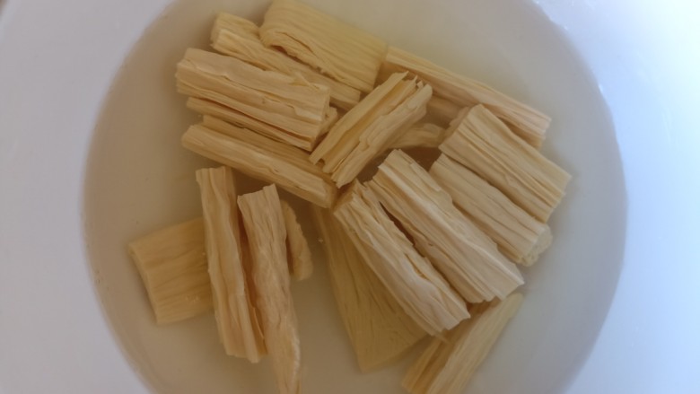 青椒炒腐竹,泡好的腐竹明显变大,捏一捏中间有没有硬心,如果中间有硬心的话,就是没有泡开,需要再泡一下。