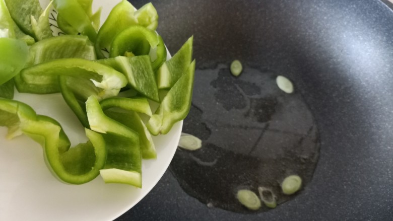 青椒炒腐竹,锅中加入少许油,加入一些葱花爆香