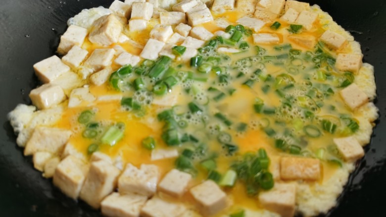 豆腐炒鸡蛋,然后倒入蛋液,快速翻炒。