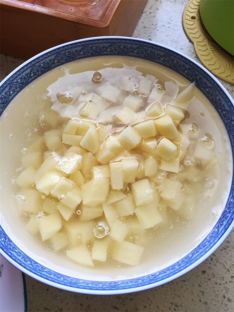 哨子面,为了防止土豆氧化,切好的土豆丁泡在清水里。