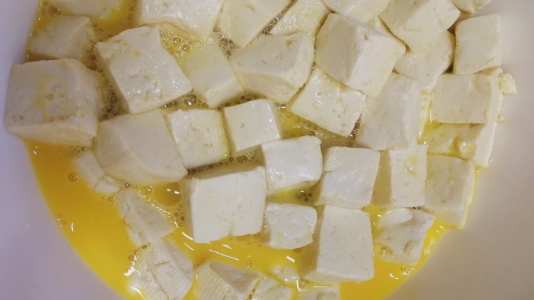 豆腐炒鸡蛋,轻轻搅拌均匀,让豆腐都裹上蛋液。