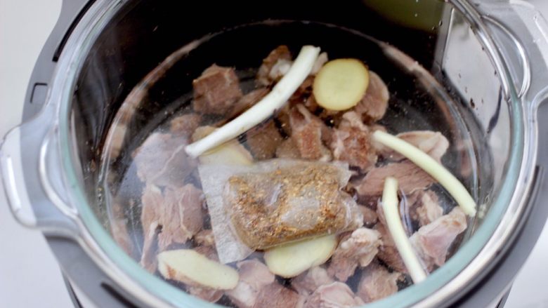 牛腩炖萝卜,放入炖牛肉调料包,剩下的葱和姜片,倒入不超过水位线的清水。