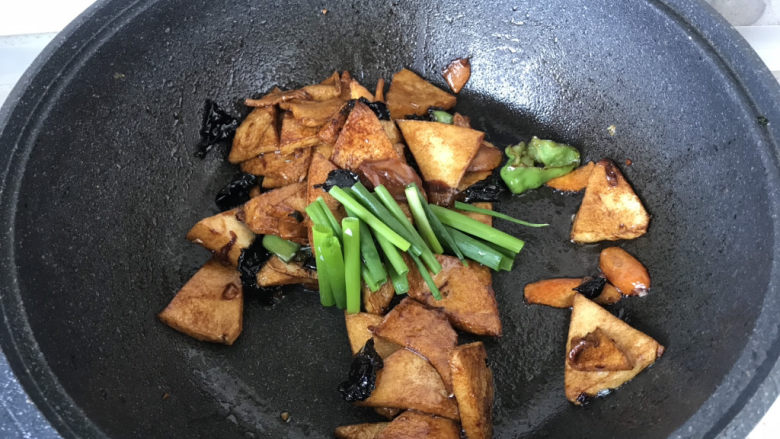 素炒千叶豆腐,翻炒均匀后,加入小葱段炒两下出锅;
