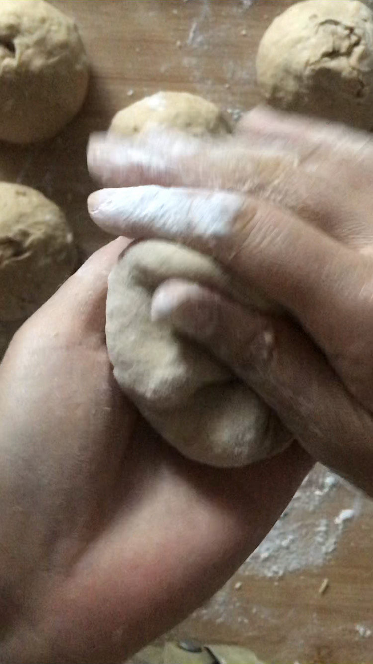 红糖开花馒头,揉好再放在手里,另一个手用拇指折出花纹,边折边转动馒头,十几下就可以了,揉好剂口朝上放在面板上