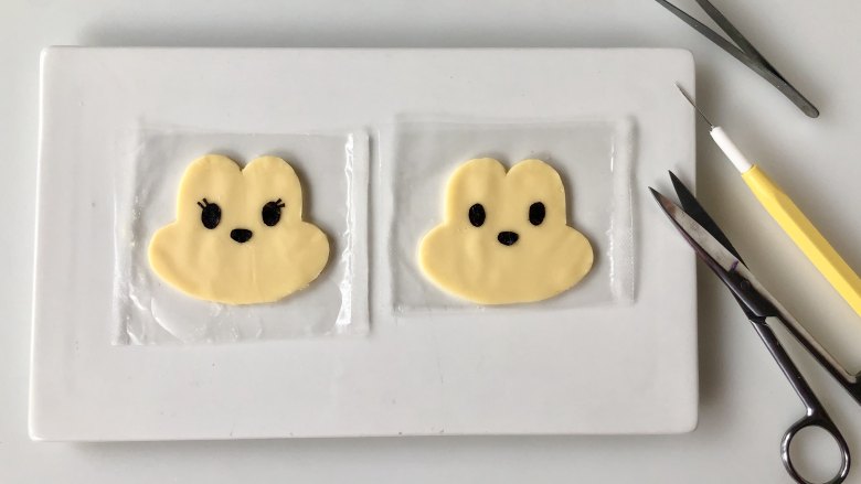 萌萌的米奇与米妮便当,在家感受迪士尼,用海苔剪出眼睛和鼻子,米妮的眼睛每一边各多两根睫毛,剪好贴到芝士片上。