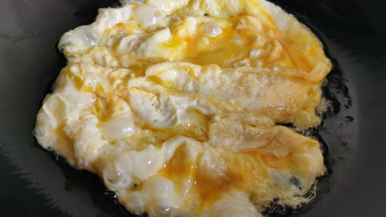白玉菇炒鸡蛋,炒锅烧热放油,倒入蛋液翻炒。
