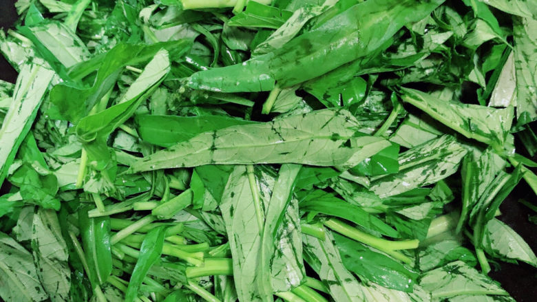 蒜蓉空心菜,再放入空心菜叶子,继续翻炒。
