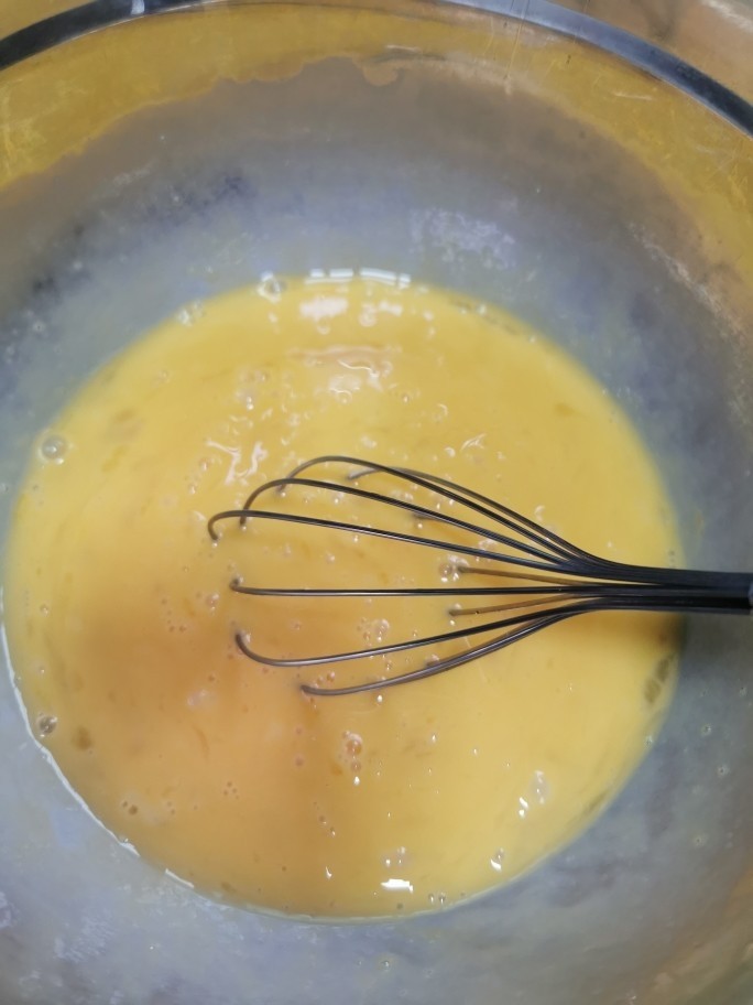 榴莲千层蛋糕,鸡蛋全部打入一个干燥大碗里,用手动打蛋器打散,不要太过用力,打出大气泡泡就不美观了