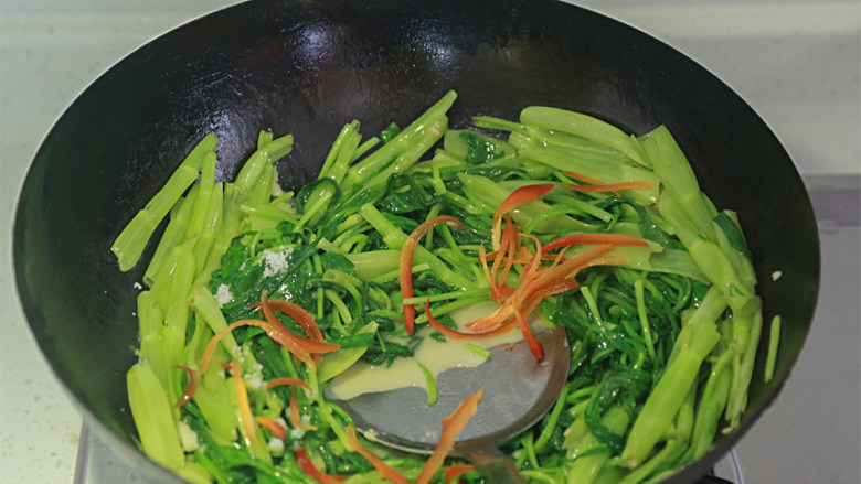 蒜蓉空心菜——80后的集体回忆,倒入腐乳继续翻炒,加入盐调味并撒上红椒丝翻炒均匀就可以出锅了。