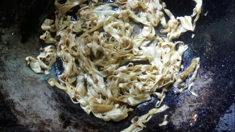 韭菜炒千张,放入千张丝翻炒,加盐。