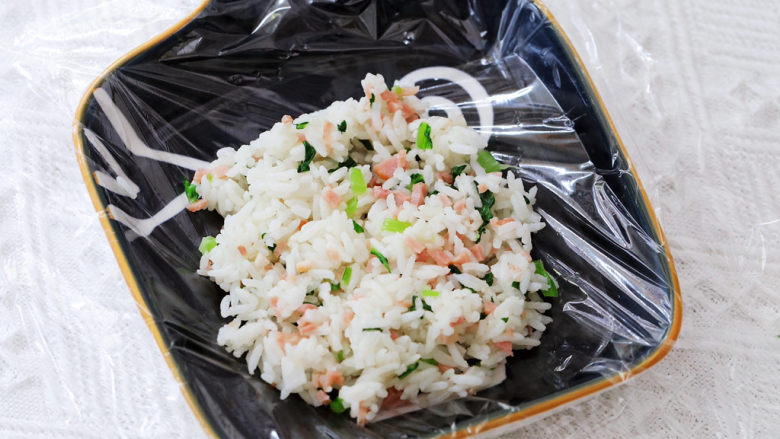 培根青菜烤饭团,盘子里先铺上保鲜膜,依次放入米饭