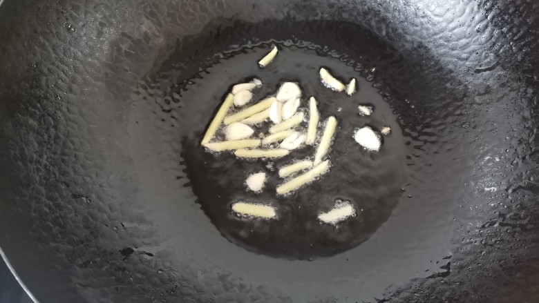 尖椒肥肠,热锅倒入适量的油,放入姜丝蒜片爆香