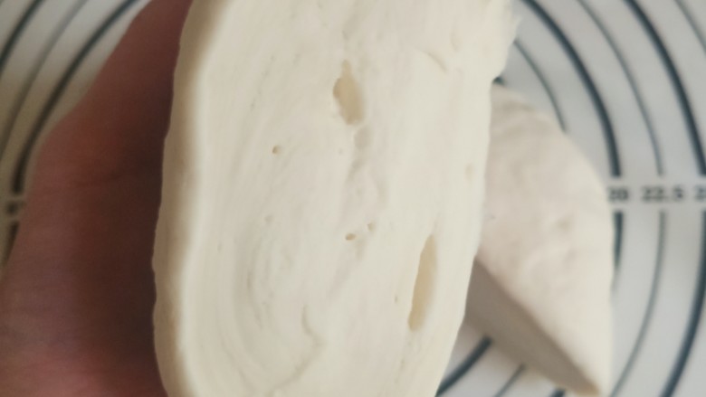 白白胖胖小馒头,这时候的面团并不光滑,切开一看,内部也不是很紧实,而且气孔大小不一