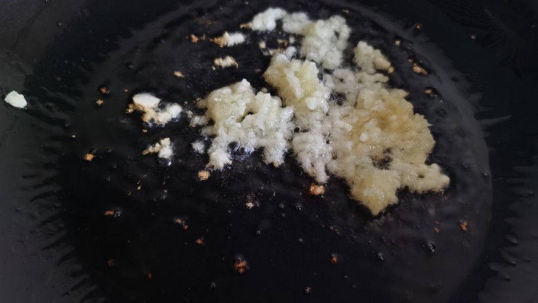 丝瓜炒虾仁,炒锅烧热放油,加入姜、蒜末,炒出香味。