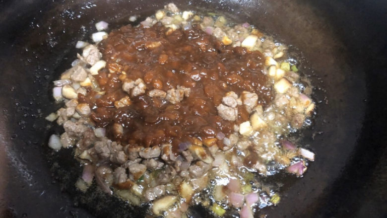 夏天里的彩色炸酱面,肉熟差不多了,把黄豆酱倒在菜上面,不用着急翻炒,就那么小火炸一会儿。所以,记得一定要多放油