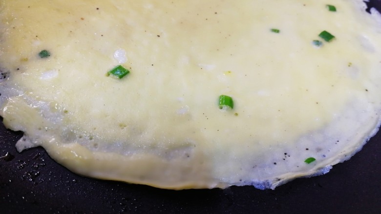 家常鸡蛋饼,这个蛋液很稀,可以摊很薄的饼。用小火,等边翘起来,就可以翻面了。