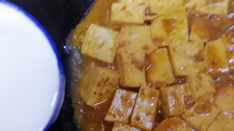 家常烧豆腐,沿锅边一圈倒入水淀粉(水淀粉倒入前搅拌一下)