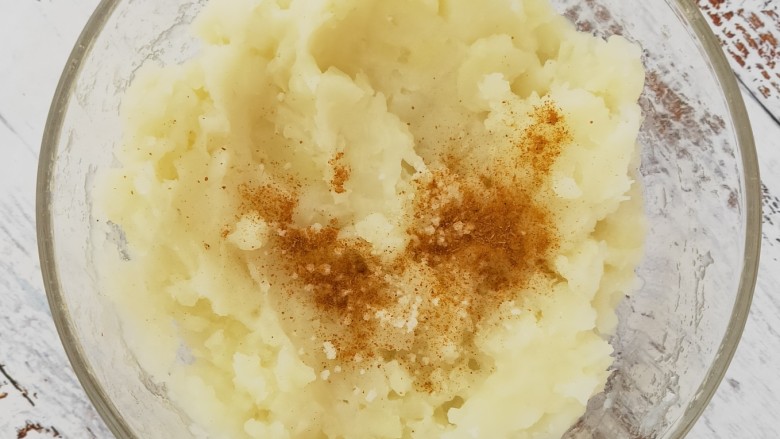 黄金土豆虾球,把蒸熟的的土豆放入碗中压成土豆泥,在放入胡椒粉,盐