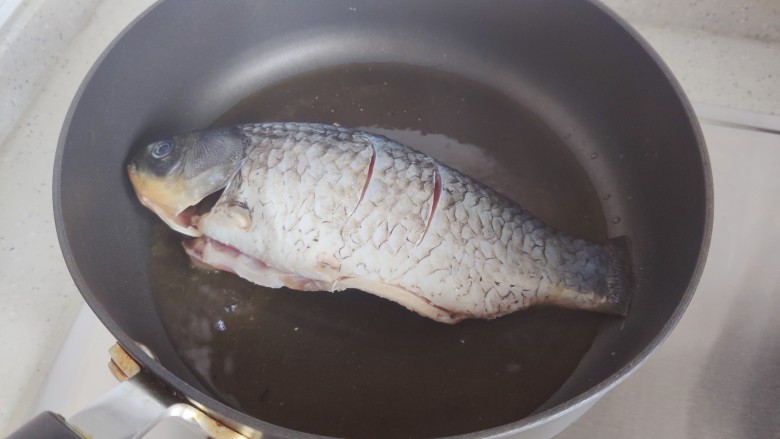 豆腐鱼头汤,待锅内油热,下鲫鱼