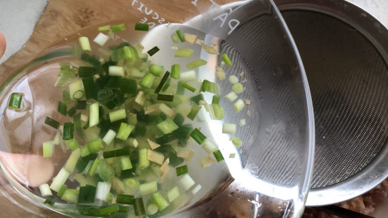 千张包肉,加调味品,分次加入葱姜水到肉糜用筷子搅拌。