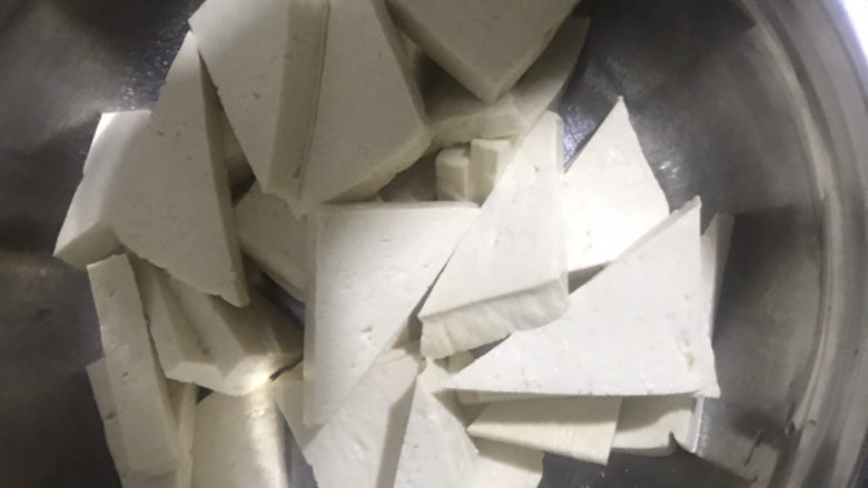 家常烧豆腐,把豆腐先切成厚片,再斜着切一刀,切成三角形,装入容器内备用