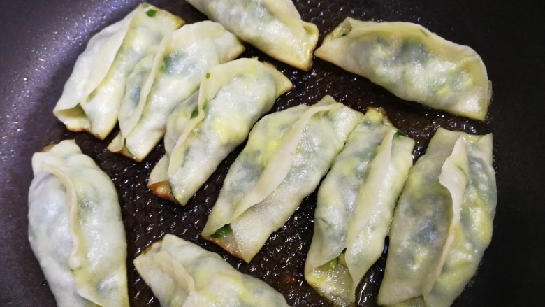 韭菜锅贴,煎至水干透,面皮透出绿色即可。
