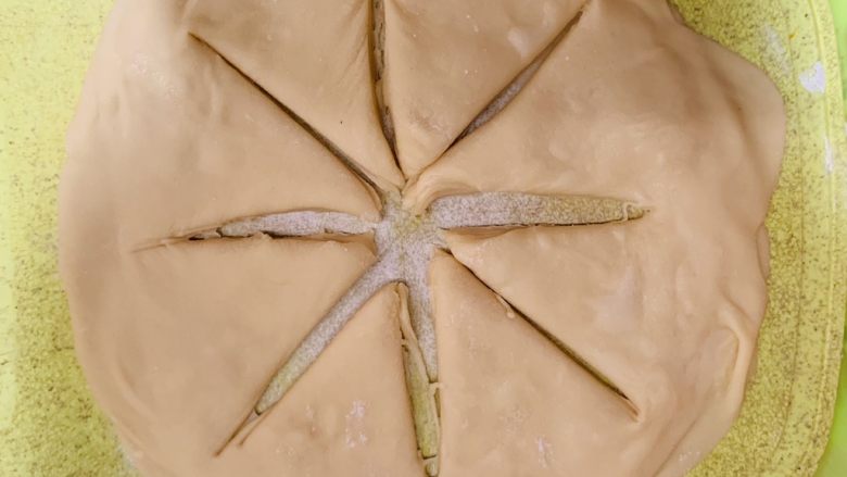 花朵千层饼,面皮放上去后用刀切8份,边边不切断。