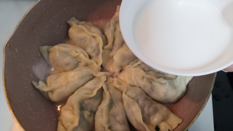 韭菜锅贴,煮至水,到锅贴三分之一处,倒入搅拌好的水淀粉