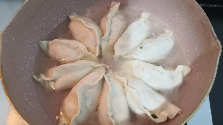 韭菜锅贴,1分钟后,倒入250克冷水,大约锅贴的三分之二处