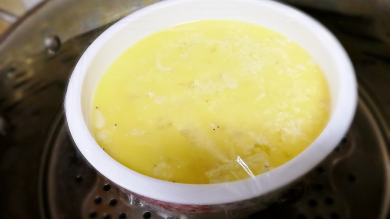 豆腐蒸蛋,盖上保鲜膜,牙签扎眼,上锅蒸,水开中小火这个碗比较深要蒸15分钟。