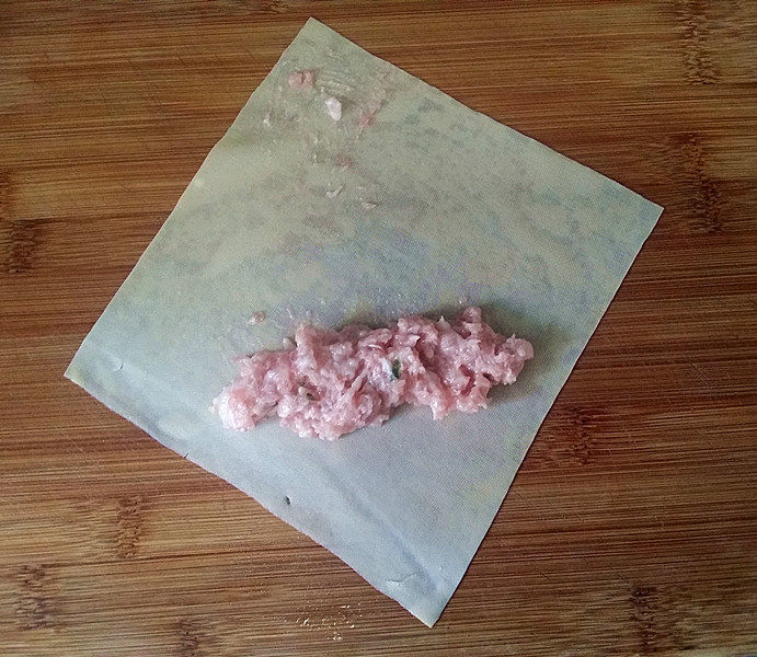 千张包肉,取一张千张,在中间放上适量肉沫,顶角也抹点肉沫