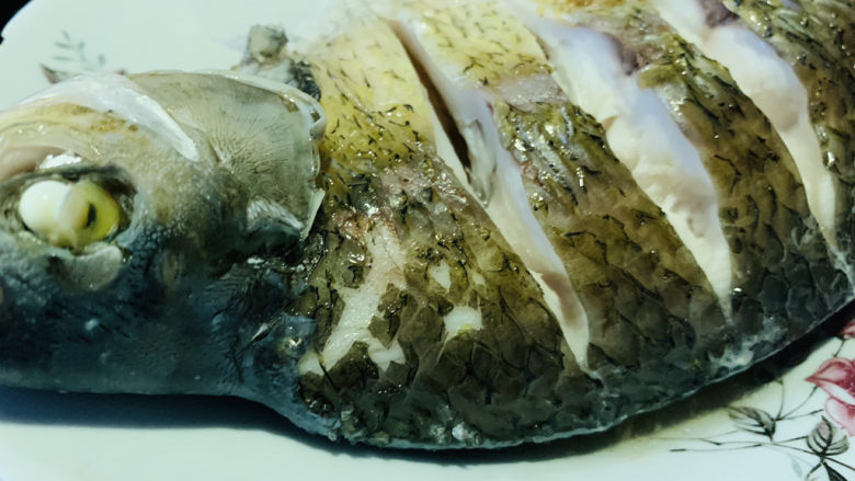 葱油鳊鱼,鱼从锅里端起来,倒掉蒸鱼水