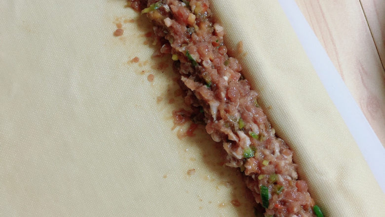 千张包肉,将豆皮打开,在中间部位放一层肉馅,将豆皮翻过来再放一层肉馅。